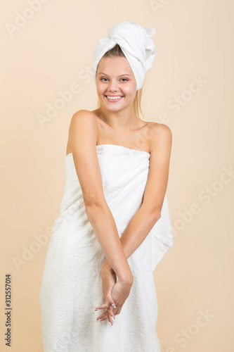 beautiful young woman on a beige background in a white towel
