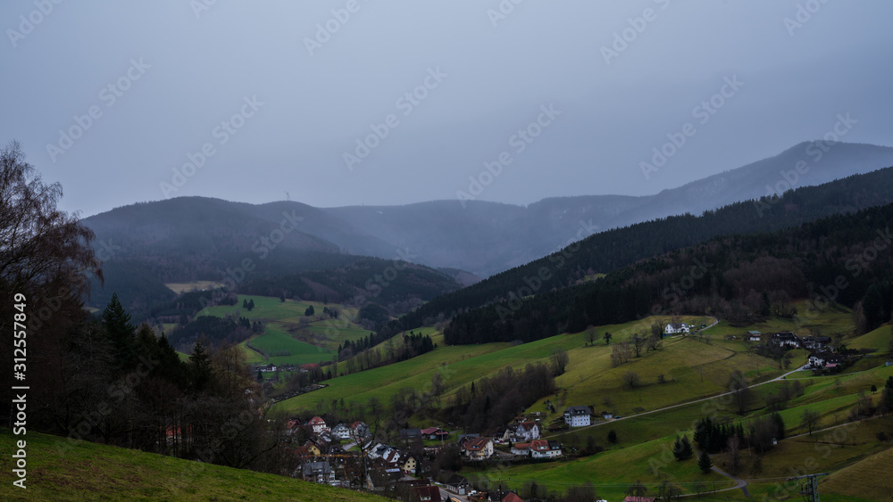 Germany, Aerial view above pretty little black forest village early morning with rain and fog in winter