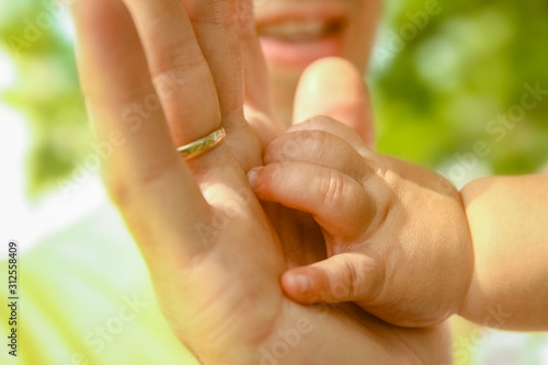 hands of a happy parent and child in nature