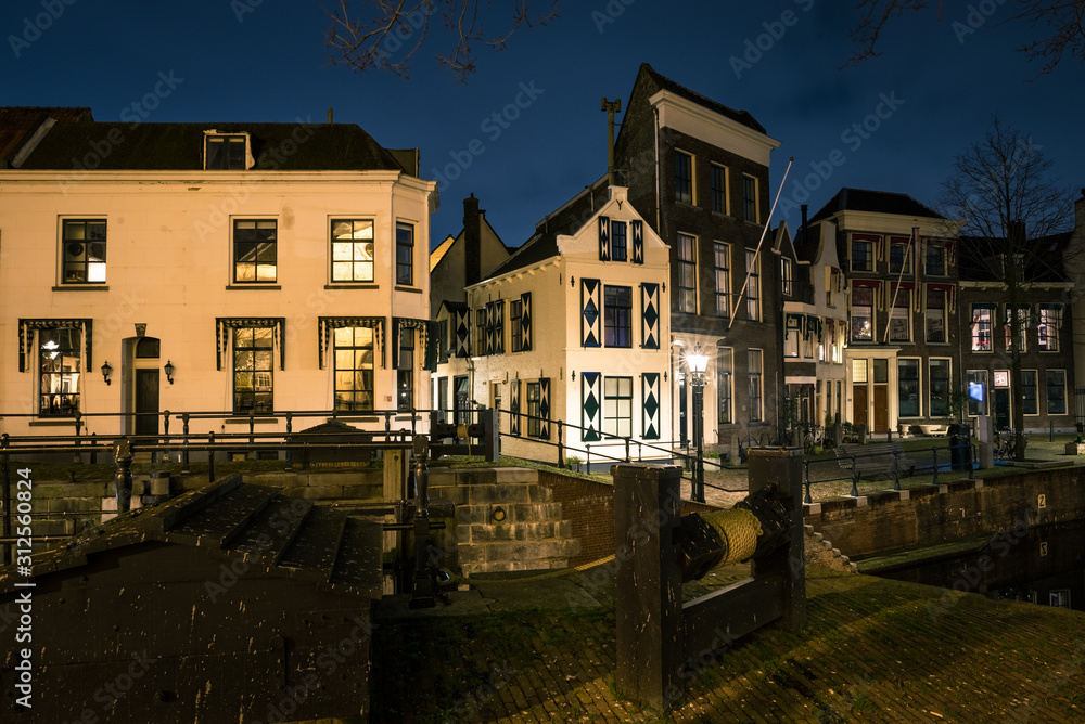 Night view of an old bridge and classic houses in the old town of Schiedam, Netherlands.