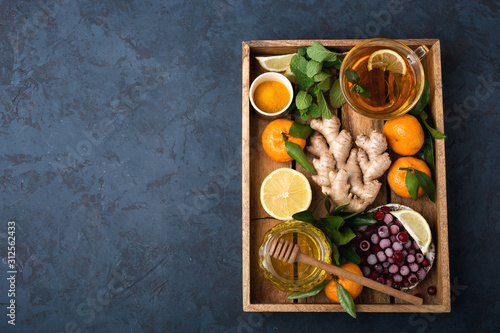 Health and diet content. Natural immune system support kit-ginger, lemon, frozen cranberries, mint tea, turmeric, tangerines. Ascorbic acid. Top view.