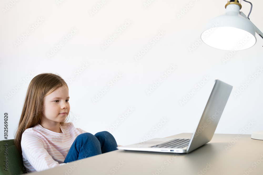 Cute little girl smiling and looking at laptop,Little girl using laptop Cute little girl smiling and looking at laptop,Little girl using laptop