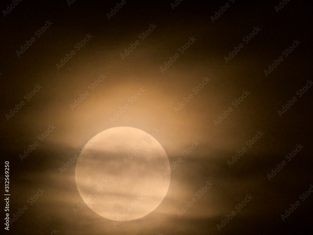 Obraz premium Full moon behind the clouds