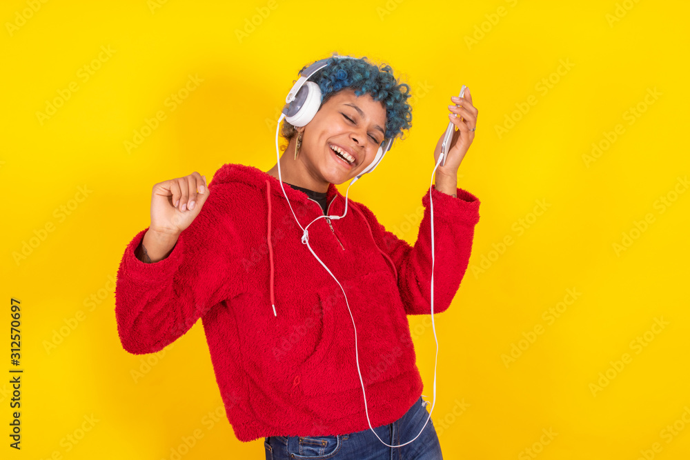 young woman or girl dancing isolated with mobile phone and headphones in color background young woman or girl dancing isolated with mobile phone and headphones in color background