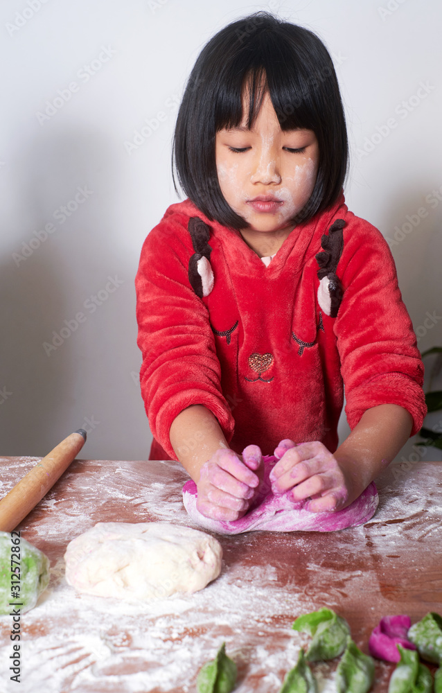 Cute asian little girl making dumplings at home Cute asian little girl making dumplings at home