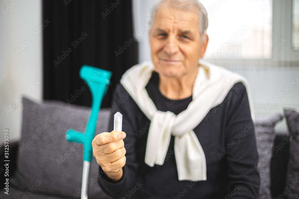 Elderly person holds a healing suppository from problems with the rectum, prostate or hemorrhoids Elderly person holds a healing suppository from problems with the rectum, prostate or hemorrhoids