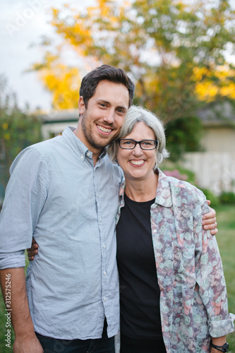 Mother and grown son together in backyard.