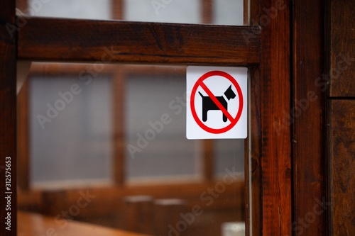 no dogs allowed sticker on wooden doorframe