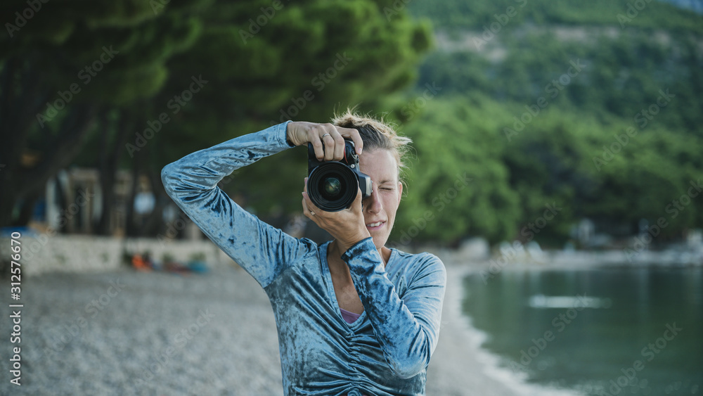 Obraz premium Front view of a young woman taking a photo directly at the camera