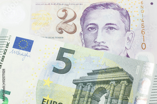 A close up image of a fve euro bank note from the European Central bank and the European Union in macro with a two dollar bill from Singapore photo