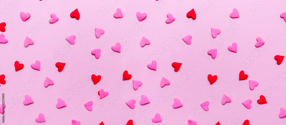 Two tone heart sprinkles on the solid pink background. Romance, love, Valentines and mother's day concept. Flat lay, horizontal wide screen banner format