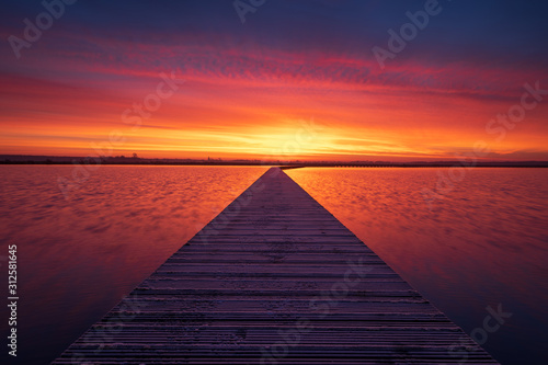 Fototapeta Naklejka Na Ścianę i Meble -  Very colorful and tranquil dawn at a jetty in a lake. Groningen, Holland.