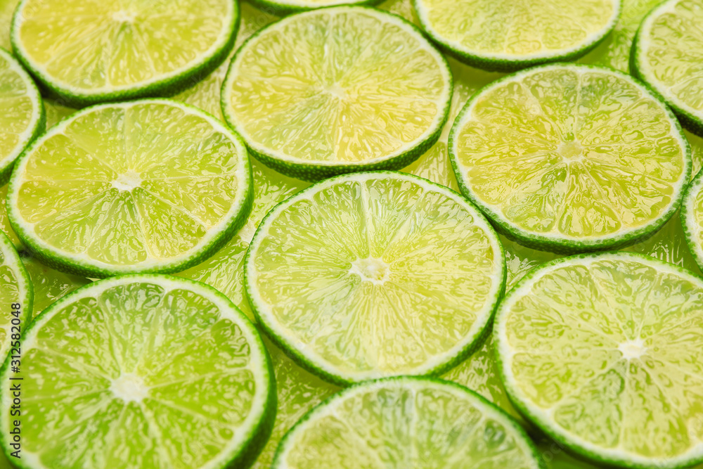 Many fresh juicy lime slices as background, closeup