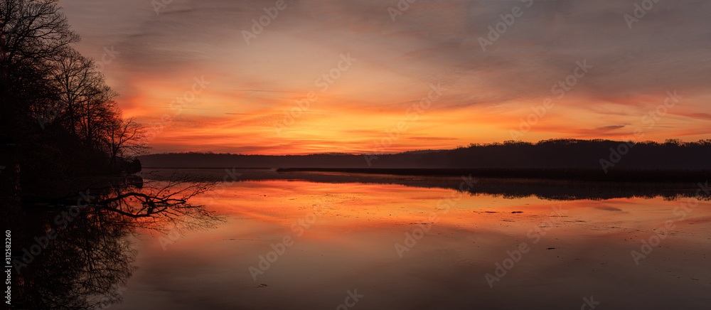 Panorama of the Horizon with a Colorful Sky and Calm River Reflections