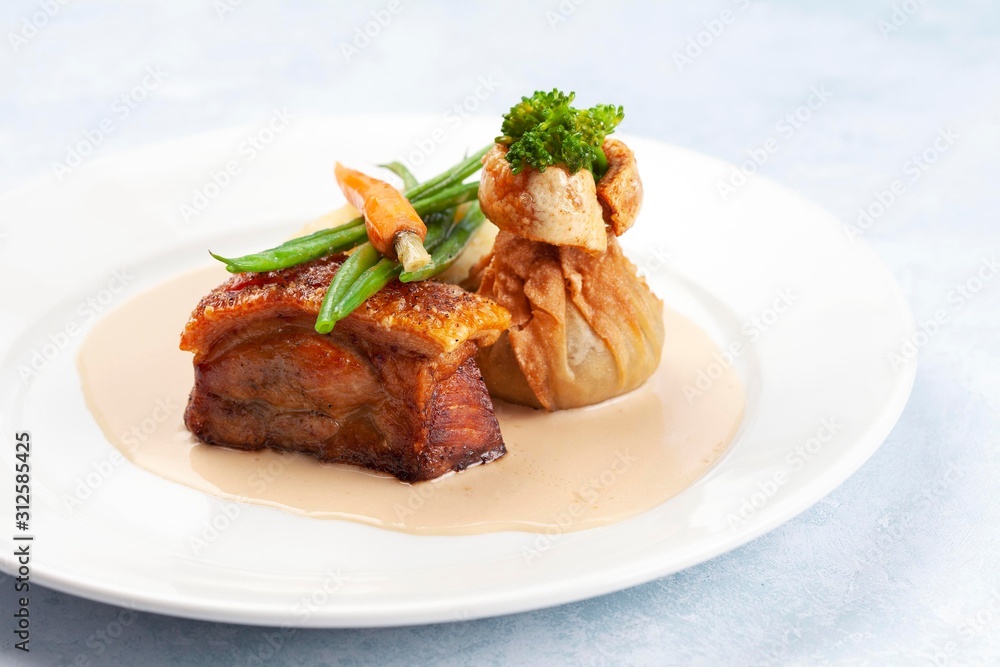 Pork belly with crackling, beans and carrots in a creamy sauce Pork belly with crackling, beans and carrots in a creamy sauce