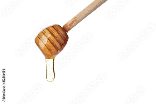 Honey dripping from wooden dipper isolated on white
