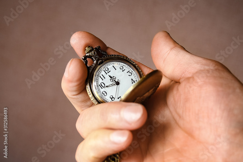 a pocket watch in the hands of a man