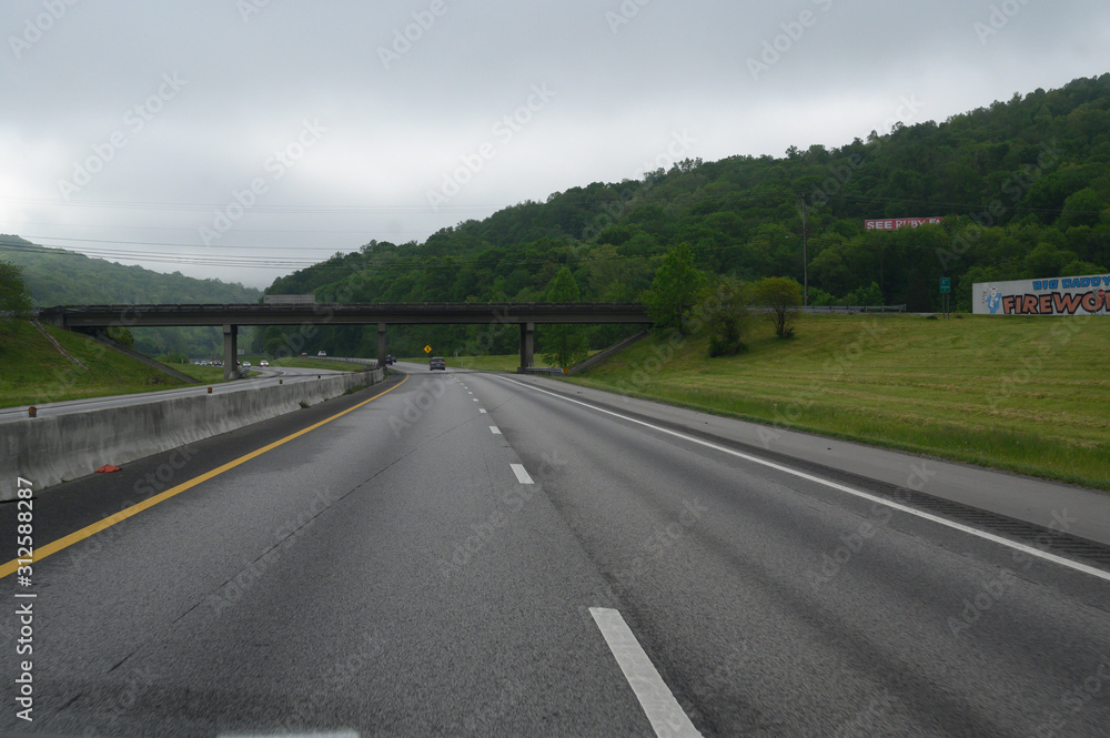 Naklejka premium Open and clear highway road with a an upcoming bridge on a cloudy overcast spring day.