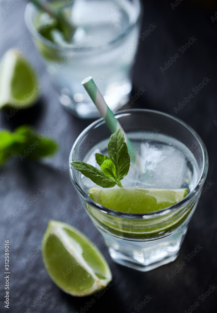 Gin and Tonic on black stone background. Close up. Gin and Tonic on black stone background. Close up.