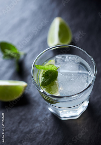Gin and Tonic on black stone background. Close up. 