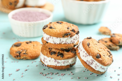 Sweet delicious ice cream cookie sandwiches on light blue wooden table, closeup