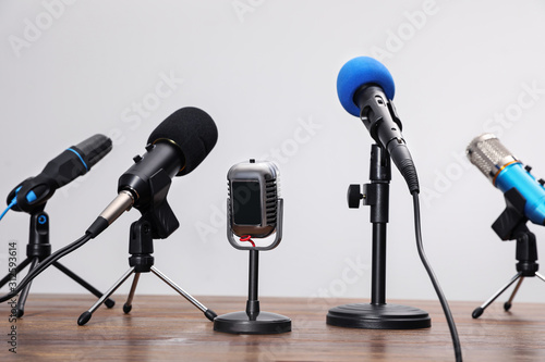Set of different microphones on wooden table. Journalist's equipment