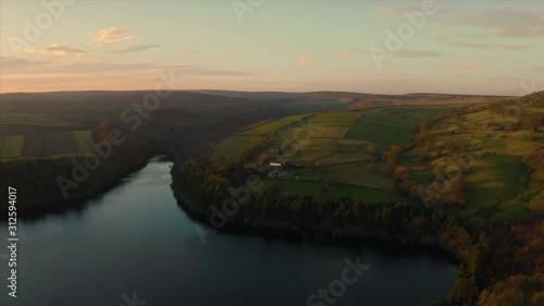 Aerial footage flying over calm still lake Agden Reservoir at sunset over Bradfield village in Sheffield, Peak District National Park, Yorkshire and Derbyshire, UK. December 2019. photo