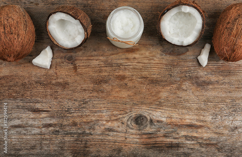 Flat lay composition with coconut oil on wooden table, space for text. Cooking ingredients