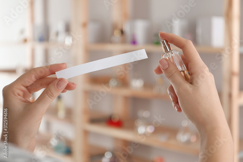 Canvas Print Woman with bottle of perfume and blotter indoors, closeup