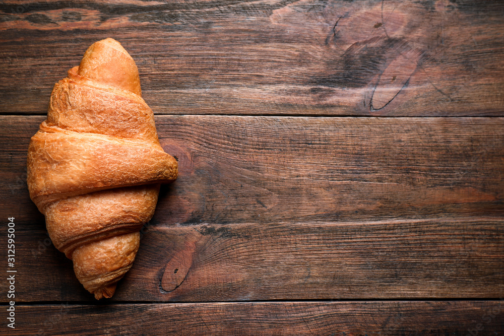 Tasty fresh croissant on wooden table, top view. Space for text Tasty fresh croissant on wooden table, top view. Space for text