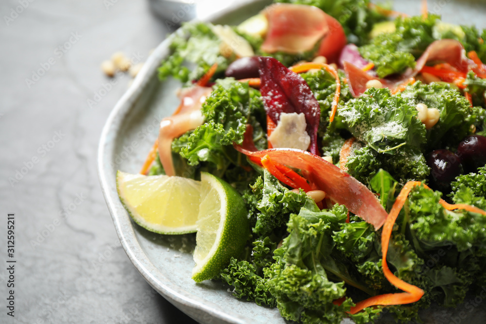 Tasty fresh kale salad on grey table, closeup Tasty fresh kale salad on grey table, closeup