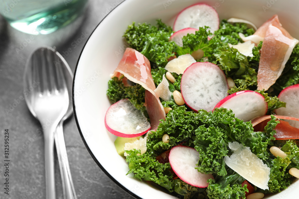Tasty fresh kale salad on grey table, closeup Tasty fresh kale salad on grey table, closeup