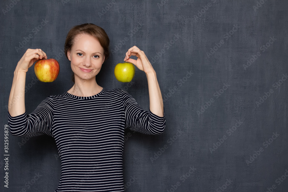Portrait of happy pretty girl smiling and holding two apples in hands Portrait of happy pretty girl smiling and holding two apples in hands