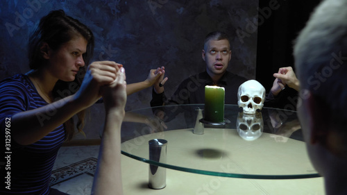Fotografija A session of spiritualism group of people sitting at a round table holding hands