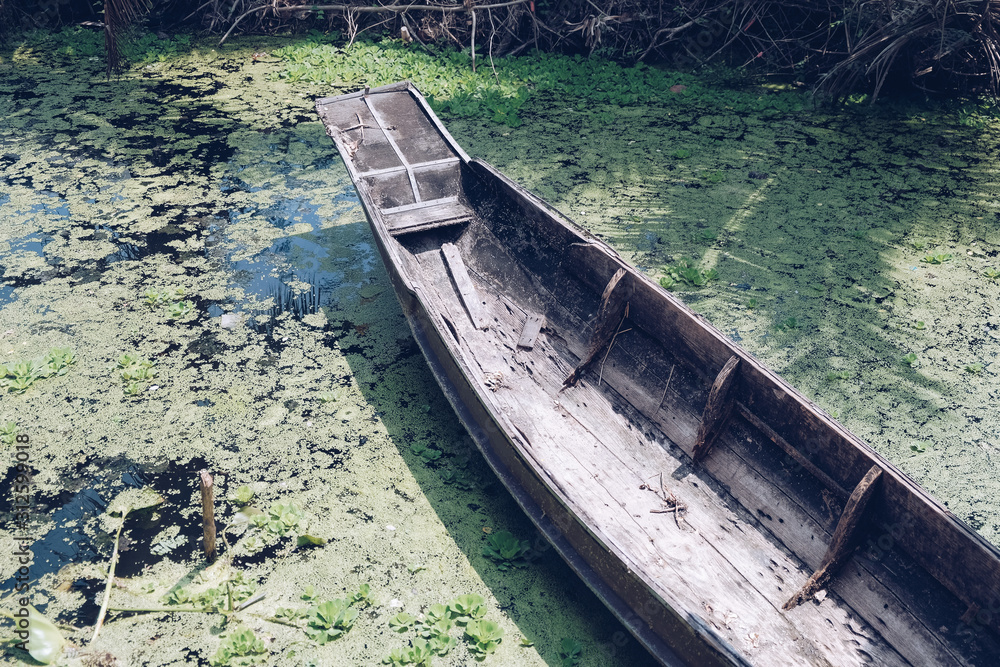 Vintage wooden boat in river. Wooden boat standing near river bank.