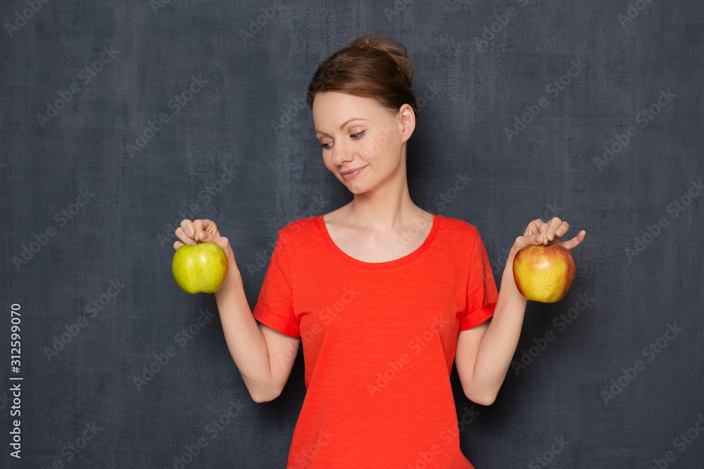 Portrait of happy young woman smiling and holding apples in hands Portrait of happy young woman smiling and holding apples in hands