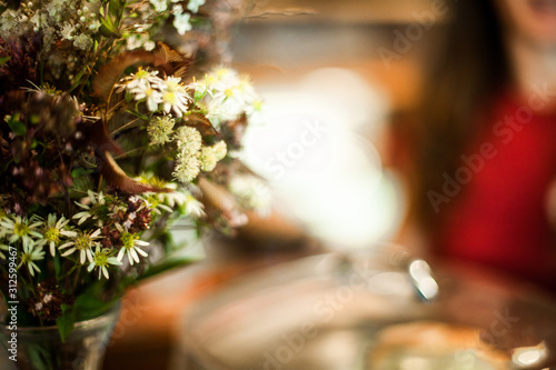 Close up shot with selective focus and blurred background of colorful little flowers and leaves. Vivid colorful floral bouquet in a glass vase.