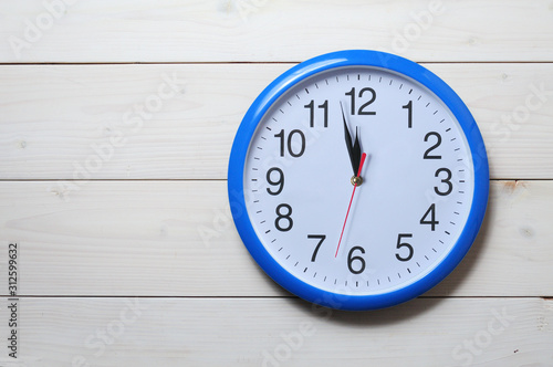 Blue wall clock on a wooden background