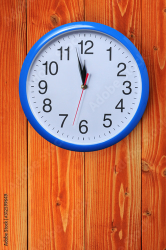 Blue wall clock on a wooden background