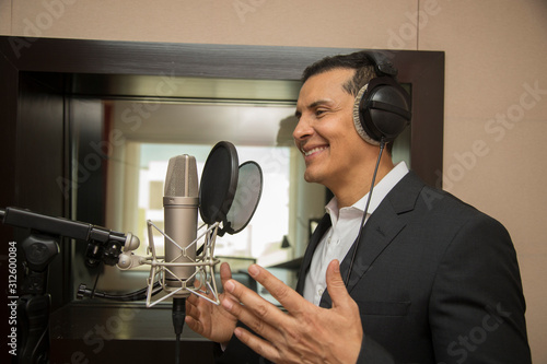 Photography actor and radio announcer with headphones and microphone working film dubbing, p