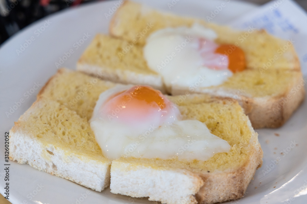 Half soft boiled eggs on toasted bread, popular Chinese breakfast