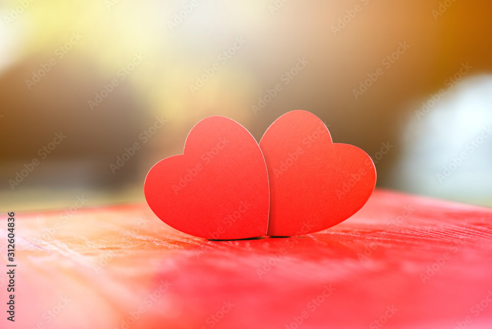 Two wooden hearts On a red wooden table Blurred background, love expression, valentine festival, love concept Two wooden hearts On a red wooden table Blurred background, love expression, valentine festival, love concept