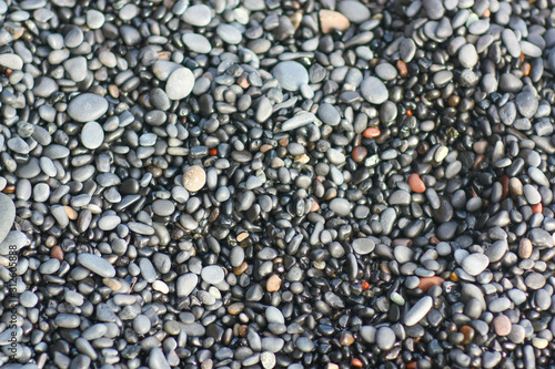 Pebble stones closeup on the shore in the blurry background