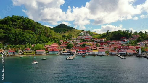French West Indies - Colorful Guest Houses At The Lush Iles Des Saintes Island Located In Guadeloupe Alongside The Blue Sea - A Perfect Tourist Destination - Wide Shot photo