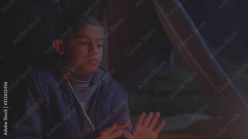 a poor boy next to the fire looking at the moon on cold night a poor boy next to the fire looking at the moon on cold night