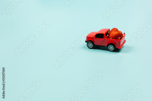  Valentines Day Concept. Retro red toy car with red heart