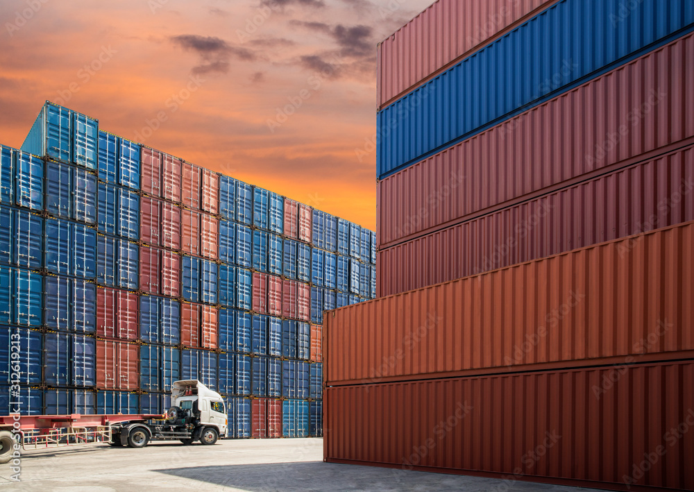 Fototapeta premium container truck drive pass logistics containers in shipyard with beautiful sunset sky in imports exports logistics area