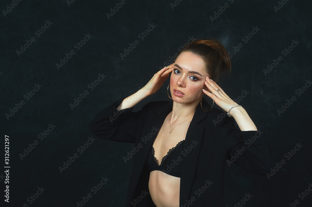 Young beautiful woman on a dark background .Elegant girl in a dark jacket and bra Young beautiful woman on a dark background .Elegant girl in a dark jacket and bra