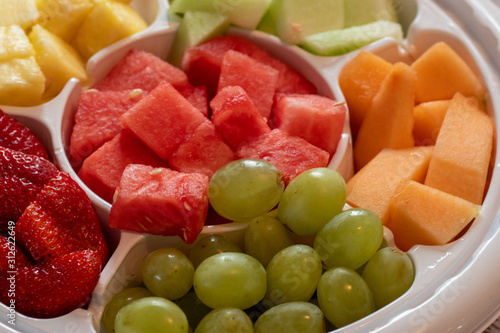 Fotografija A Platter of Fruit Served in a White Plastic Tray