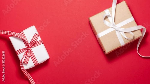 Two gift box with a red and white ribbon bow on red background. Flat lay top view stop motion animation